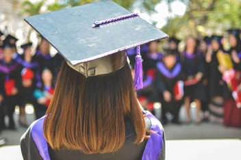 woman with her back turned wearing a graduation cap 
